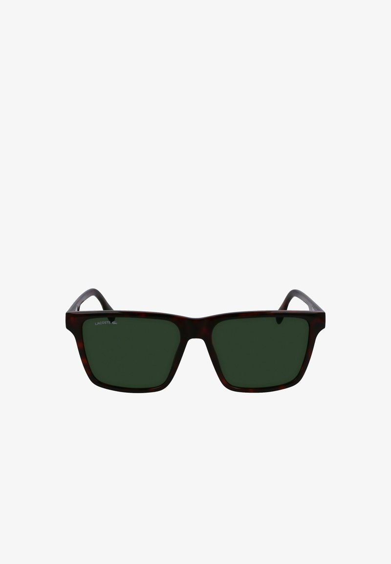 Kilpkonnakujulised ruudukujulised prillid tumeroheliste läätsedega. Vasakul templil on Lacoste logo. Plastikraam sujuva viimistlusega.