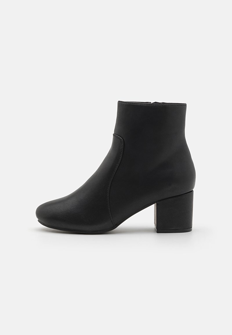 Bottine noire à cheville avec un bout arrondi et un talon bloc, texture lisse et fermeture éclair latérale sur fond blanc.