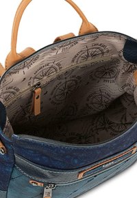 Bolso de tela azul y verde azulado con asas de cuero marrón, cierre de cremallera y forro interior con un estampado de brújula y un bolsillo con cremallera.