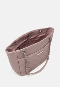 Sac fourre-tout rose avec texture matelassée, ferrures argentées et doubles anses en chaîne. L'intérieur comprend une doublure lisse et une poche zippée.