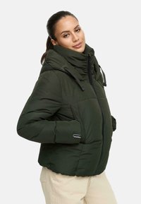 Groene gewatteerde jas met een hoge hals, ritssluiting en elastische manchetten. Bevat een logo op de linkermouw en heeft een boxy pasvorm.