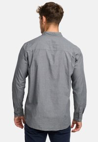 Harmaa pitkähihainen paita, jossa on napillinen kaulus, teksturoitu kangas ja napilliset kalvosimet, näyttäen rennon istuvuuden ja suoran helman.