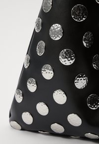 Black leather bag featuring large, hammered silver metal studs arranged in a scattered pattern across the surface.