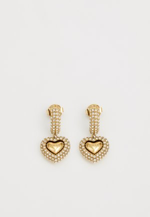 Orecchini in tono oro con pendenti a forma di cuore decorati con strass trasparenti e un cuore centrale in oro inciso con "GUESS".