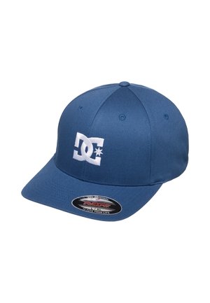 Niebieska dopasowana czapka baseballowa z białym logo DC z przodu oraz czarną owalną naklejką Flexfit na daszku, wskazującą duży rozmiar L/XL.