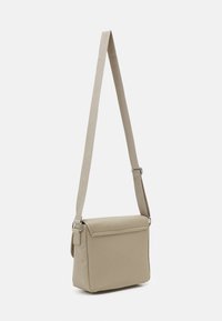 Beige Umhängetasche aus glattem Material, mit Klappenverschluss, verstellbarem Trageriemen und minimalistischem rechteckigen Design.