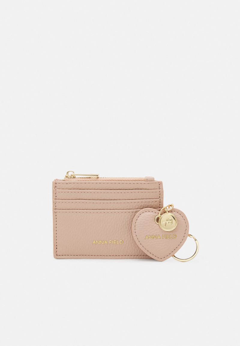 Compact pink leather cardholder with multiple slots and a gold zipper. Features a heart-shaped charm attached with a keyring.