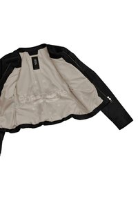Giacca in pelle nera con un interno beige. Presenta una texture liscia, chiusura con zip e un delicato motivo floreale all'interno.