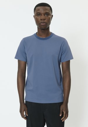 Tričko s krátkym rukávom a okrúhlym výstrihom v jemnej modrej farbe, s malým logom na hrudi a voľným strihom.