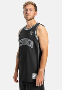 Čierny basketbalový dres vyrobený z priedušného materiálu. Obsahuje šedé akcenty, okrúhly výstrih a výrazné logo s nápisom na prednej strane.