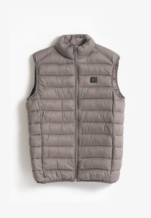 Chaleco aislante gris con cuello alto, diseño acolchado, cremallera frontal y pequeño parche de logo negro en el lado izquierdo. Textura suave.