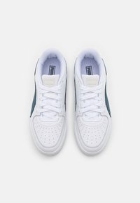 Valged spordijalatsid roheliste akcentidega, sile nahast ülemine osa, perforatsiooniga varbakast, lame nöörid ja polsterdatud sisetallad. Lihtne, sportlik disain.