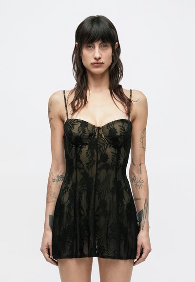 Robe en dentelle noire avec un corsage ajusté, des bretelles fines et une jupe évasée. Présente un motif floral et une texture transparente.