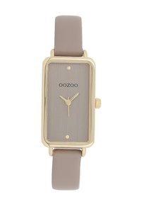 Montre rectangulaire avec un cadran gris brossé, des éléments en ton or et un bracelet en cuir marron clair. Comprend deux marqueurs d'heure dorés et le logo de la marque.
