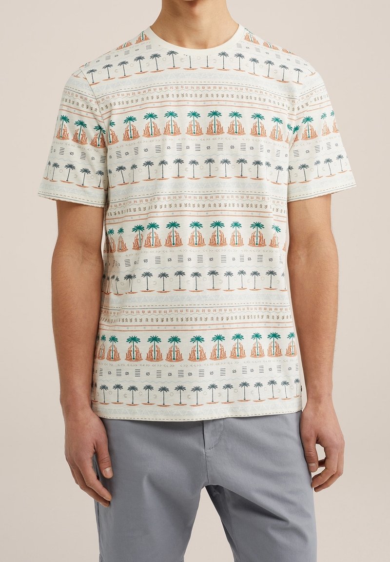 Krótki rękaw, bawełniana koszulka w kolorze beżowym z wzorami palm i krajobrazu w odcieniach zieleni i pomarańczu. Okrągły dekolt, luźny krój, gładka tekstura.