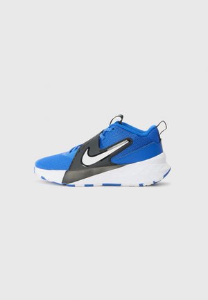 Sininen urheilukenkä, jossa on verkkomateriaali päällä, mustat synteettiset yksityiskohdat, valkoinen ja sininen pohja sekä näkyvä Nike-logo sivussa.