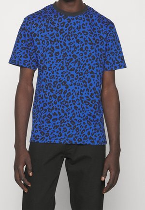 Niebieski t-shirt z czarnym wzorem w panterkę, krótkie rękawy, okrągły dekolt, wykonany z miękkiej tkaniny, luźny krój.