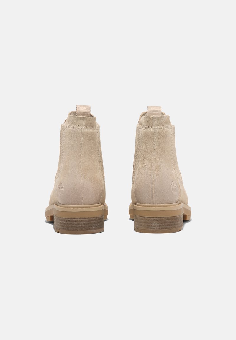 Bottines en suédine beige avec une texture lisse, panneaux latéraux élastiques et un talon empilé en bois. Logo sur le talon.