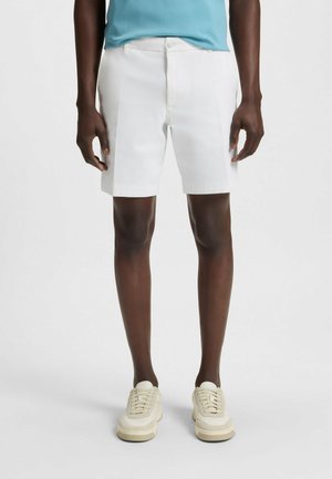 Shorts bianchi realizzati in cotone leggero con una texture liscia, dotati di vita standard, tasche frontali e una vestibilità su misura.