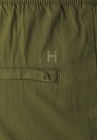 Oliwkowy, lekki materiał o teksturowanym wykończeniu. Posiada elastyczny pas oraz małą kieszonkę z kontrastowym przeszyciem. Oznaczony znakiem "/H".