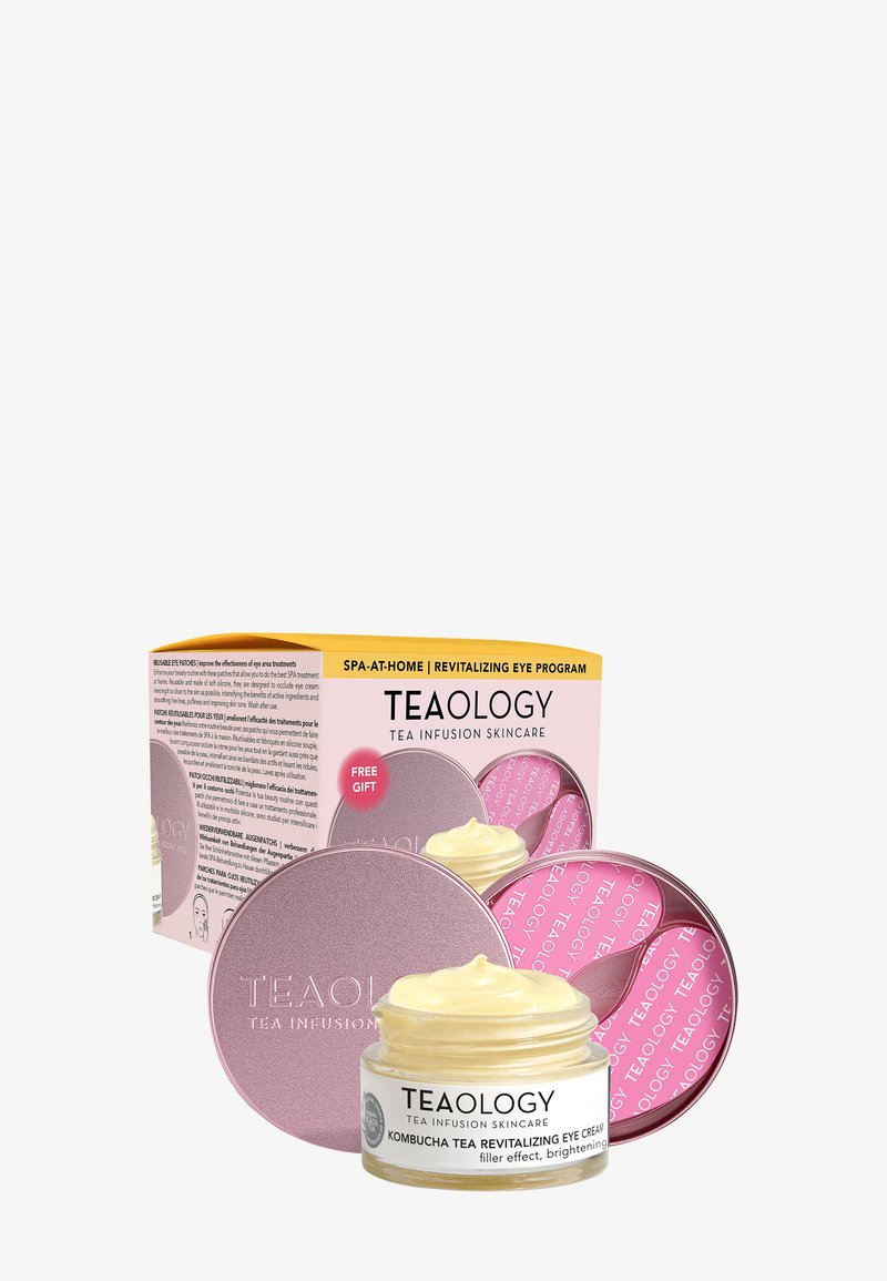 Crème pour les yeux revitalisante Teaology Kombucha dans un pot avec couvercle métallique rose et une boîte de produit étiquetée Programme revitalisant pour les yeux SPA À DOMICILE.