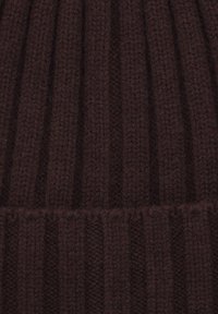 Brązowa dziana czapka z prążkowanym wzorem, teksturowanym materiałem i podwiniętym mankietem dla dodatkowego ciepła.