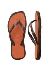 Tongs en caoutchouc marron avec un pied texturé beige. Elles disposent de larges sangles marron foncé avec un motif en zigzag et un détail de logo.
