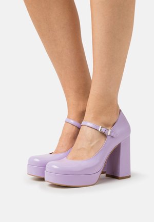 Chaussures à plateforme en cuir verni violet avec un talon épais, dotées d'un bout fermé et d'une fine bride de cheville avec une boucle en métal.