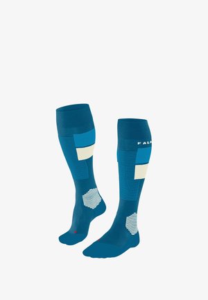 Calze blu fino al ginocchio con blocchi di colore geometrici; righe e motivi testurizzati, punta rinforzata e accento rosso alla base.