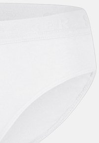 Sous-vêtements en coton blanc avec une taille douce arborant un logo texturé subtil. Fini lisse et conception de slip basique.