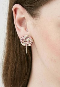 Orecchini in tono oro con un design rotondo a spirale, impreziositi da pietre multicolori, principalmente rosa e trasparenti, montate su una superficie testurizzata.
