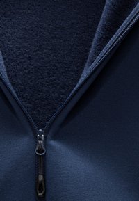 Marine blauwe ritssluiter fleece met een zachte, gestructureerde binnenvoering en een gladde buitenlaag. Beschikt over een stevige rits en een modern kraagontwerp.