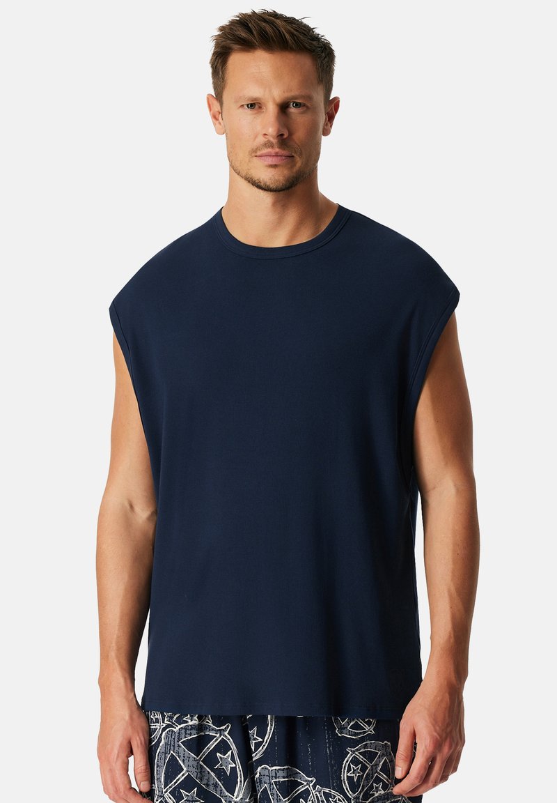 Donkerblauwe mouwloze T-shirt met een ronde hals en een ontspannen snit. Gemaakt van zachte, gestructureerde stof, met een strakke, minimalistische uitstraling.