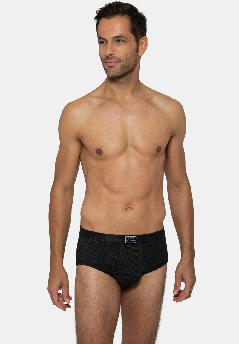 Schwarze Baumwollslips, gerippte Struktur, elastischer Bund mit Logo. Enger Schnitt, mittelhoher Bund und einfarbig ohne zusätzliche Muster.