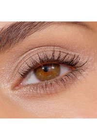 Nærbillede af et øje med hasselbrun iriss, veldefinerede vipper og skinnende beige øjenskygge. Huden omkring øjet er glat med naturlige toner.