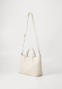 Biała torebka z teksturowanym wzorem, podwójnymi górnymi uchwytami oraz odpinanym paskiem na ramię. Wyposażona w elementy ozdobne w złotym odcieniu.