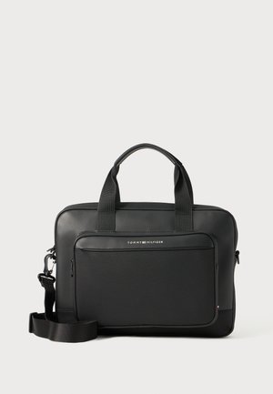 Black laptop bag with a smooth finish, dual top handles, adjustable strap, front zip pocket, and a silver logo detail. Textured accents visible.