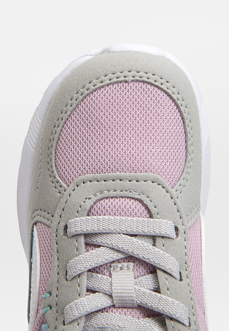 Sneaker rosa chiaro con tomaia in rete testurizzata, accenti in suede grigio e suola in gomma bianca. Presenta lacci grigi e un design cucito.