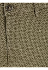 Tessuto marrone a motivo con un design geometrico e una texture liscia. Include un bottone in vita. Adatto per pantaloni.