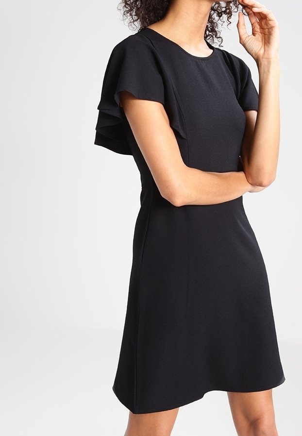 Robe noire à manches courtes avec volants aux manches, en tissu lisse, présentant un col rond classique et un ourlet légèrement évasé.