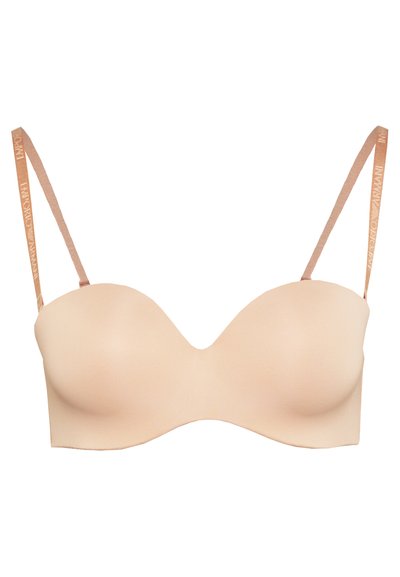 Soutien-gorge à armatures en tissu beige doux. Coupes galbées avec bretelles réglables marron clair ornées de logos. Design lisse et sans couture.