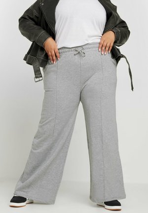 Pantalons de survêtement gris à jambes larges avec un cordon de serrage à la taille, fabriqués en tissu doux. Présente des détails de couture subtils et une coupe décontractée.