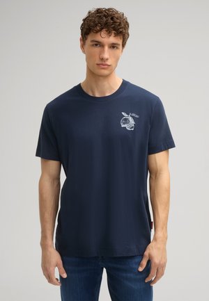 Navyblauw katoenen T-shirt met een witte grafische print op de linkerborst, korte mouwen en een ronde hals. Gladde textuur en een ontspannen pasvorm.