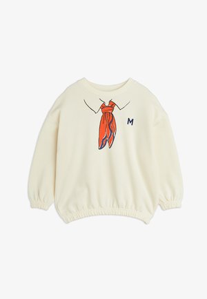 Felpa color crema con colletto rotondo, polsini elastici, caratterizzata da un'illustrazione di una sciarpa rossa e una "M" blu sul davanti. Tessuto morbido.