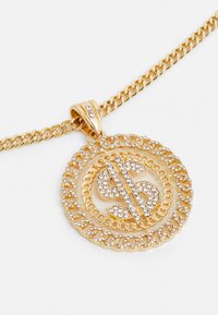 Gouden ketting met een dollarteken-hanger, versierd met heldere rhinestenen, gezet in een gestructureerd, gedraaid touwontwerp.