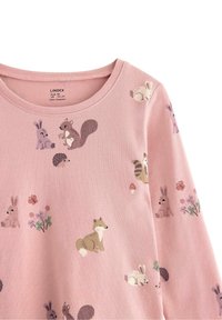 Vaaleanpunainen pitkähihaisa paita, jossa on leikkisiä eläin- ja kukkakuoseja, mukaan lukien kaneja, kettu ja siili. Pehmeä kangas.