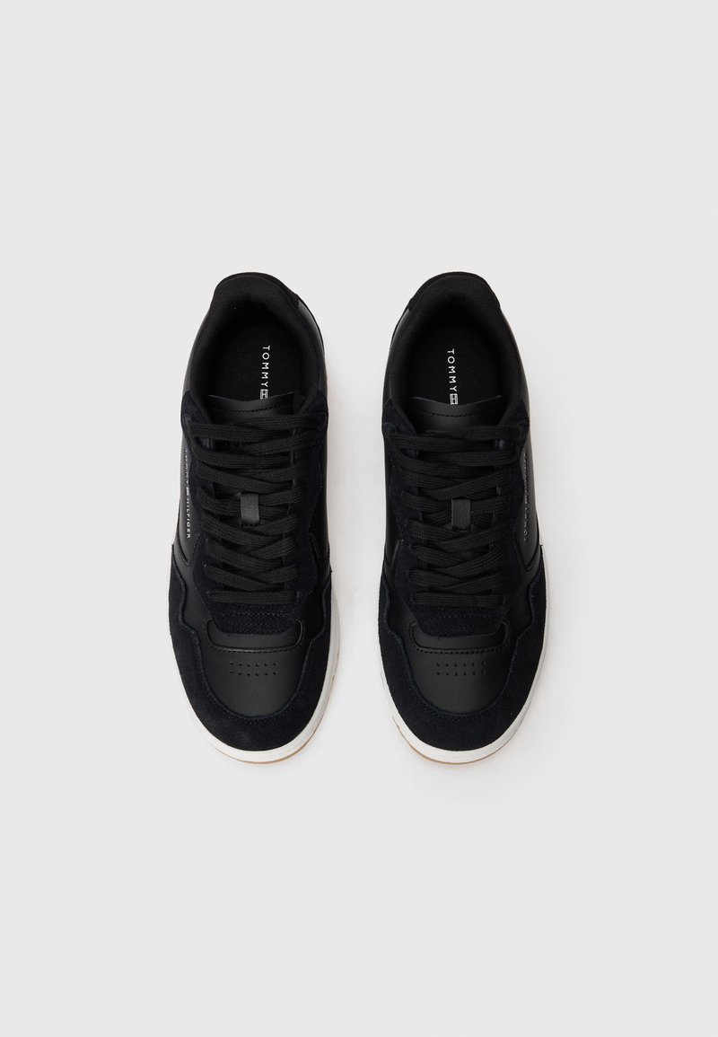 Schwarze Sneakers aus einer Kombination von Leder und Wildleder, runde Zehenform und Schnürdesign; weiße Gummisohle mit niedriger Höhe.