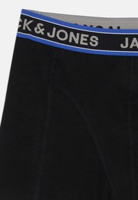 Zwarte boxers vervaardigd uit zacht materiaal, met een contrasterende tailleband waarop "JACK & JONES" in witte en blauwe accenten staat. Gedetailleerde stiksels zichtbaar.