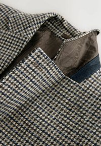 Villane segu kašmiirblazer, mis on kaetud halli, sinise ja beeži houndstooth-mustriga, halli satiinvoodriga ning tekstuurse kraega.