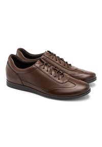 Brązowe skórzane buty o gładkim i perforowanym wzorze, z zaokrąglonym noskiem i sznurowaniem. Charakteryzują się elegancką sylwetką i płaską podeszwą.